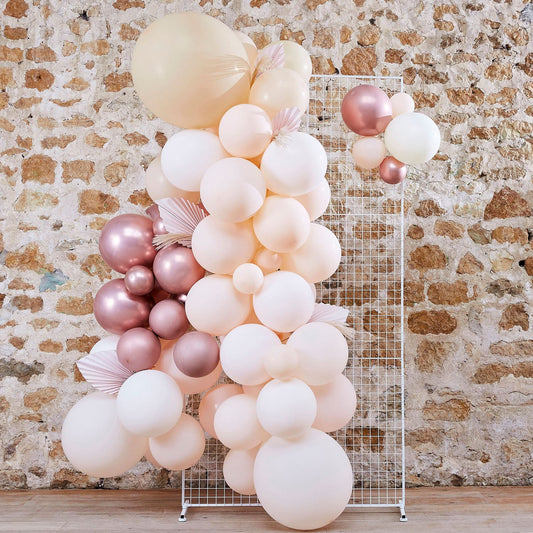 Arche à ballons rose gold, rose pastel, pêche, nude, blancs pour EVJF ou mariage avec de la pampa